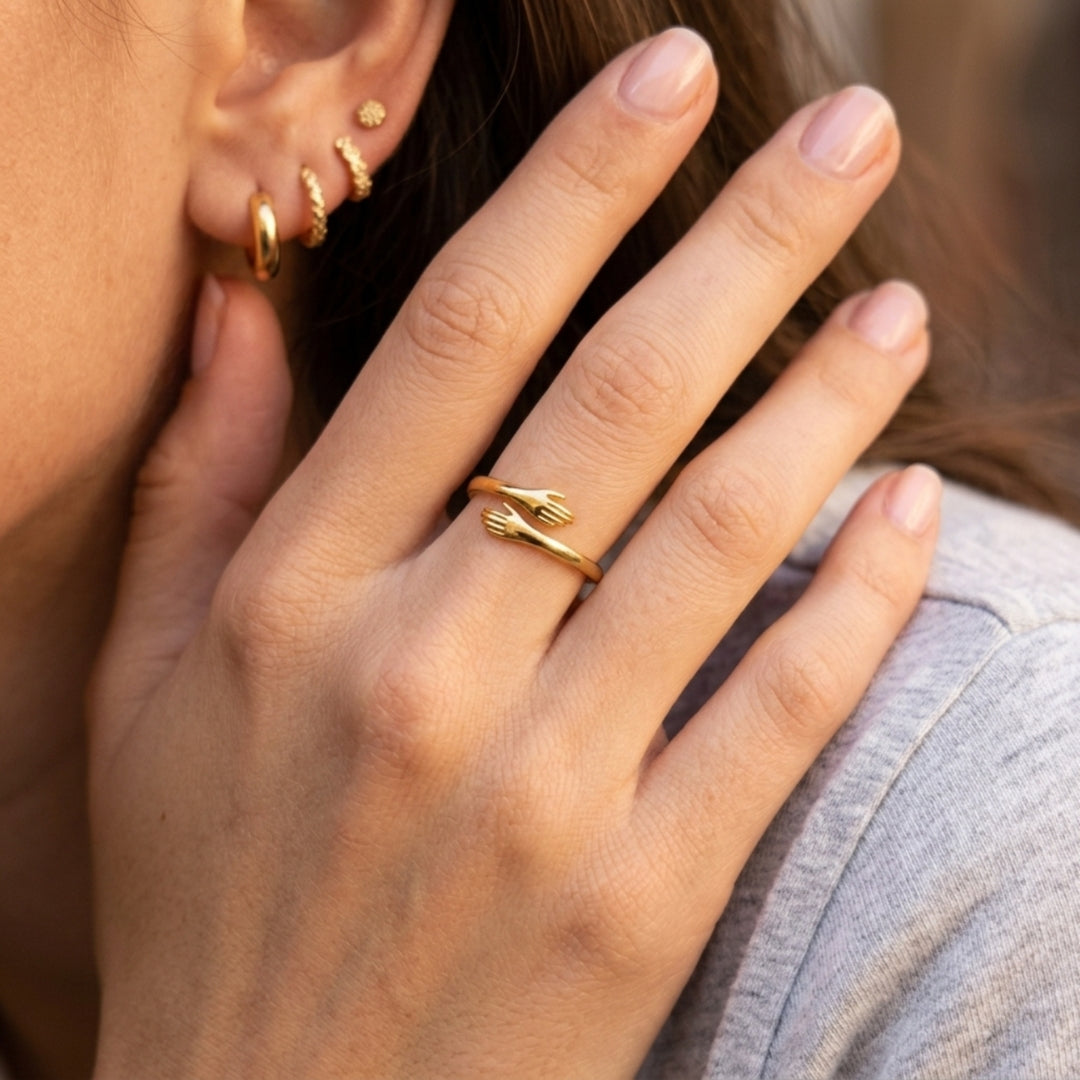 Anillo Abrazo Eterno dorado puesto, visto de cerca en la mano