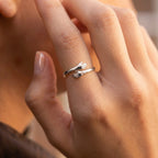Anillo Abrazo Eterno plateado puesto en el dedo