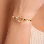 Pulsera de infinito y corazón en oro puesta en la muñeca