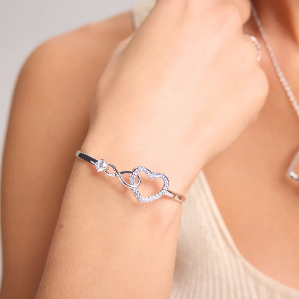Pulsera de infinito y corazón en plata puesta en la muñeca