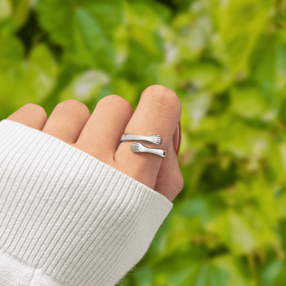 Anillo abrazo de acero inoxidable puesto en el dedo, con los dos brazos rodeándolo