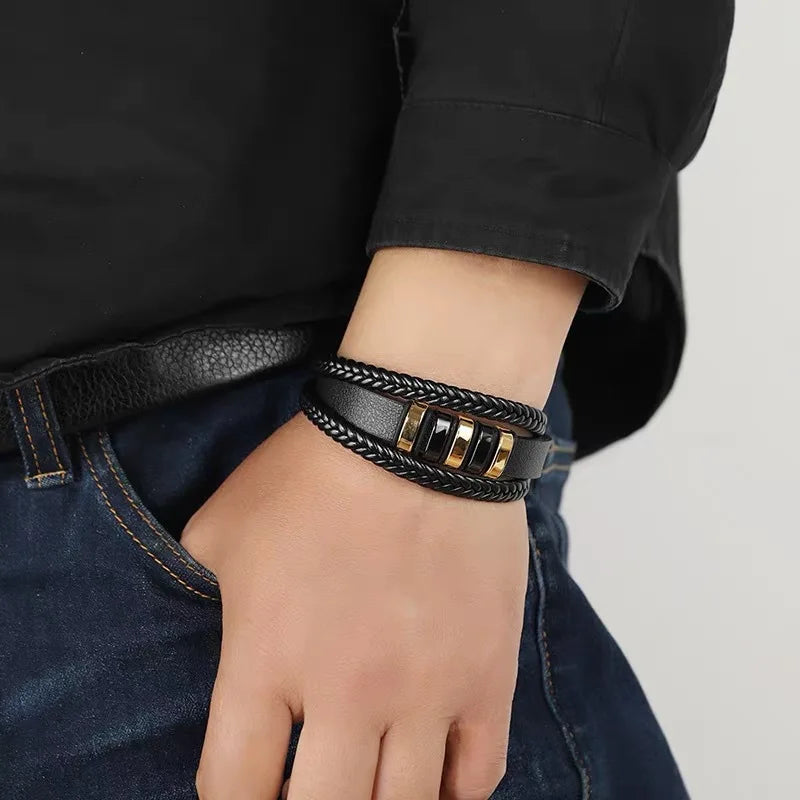 Pulsera de cuero trenzado puesta en la muñeca, con camisa negra y vaqueros