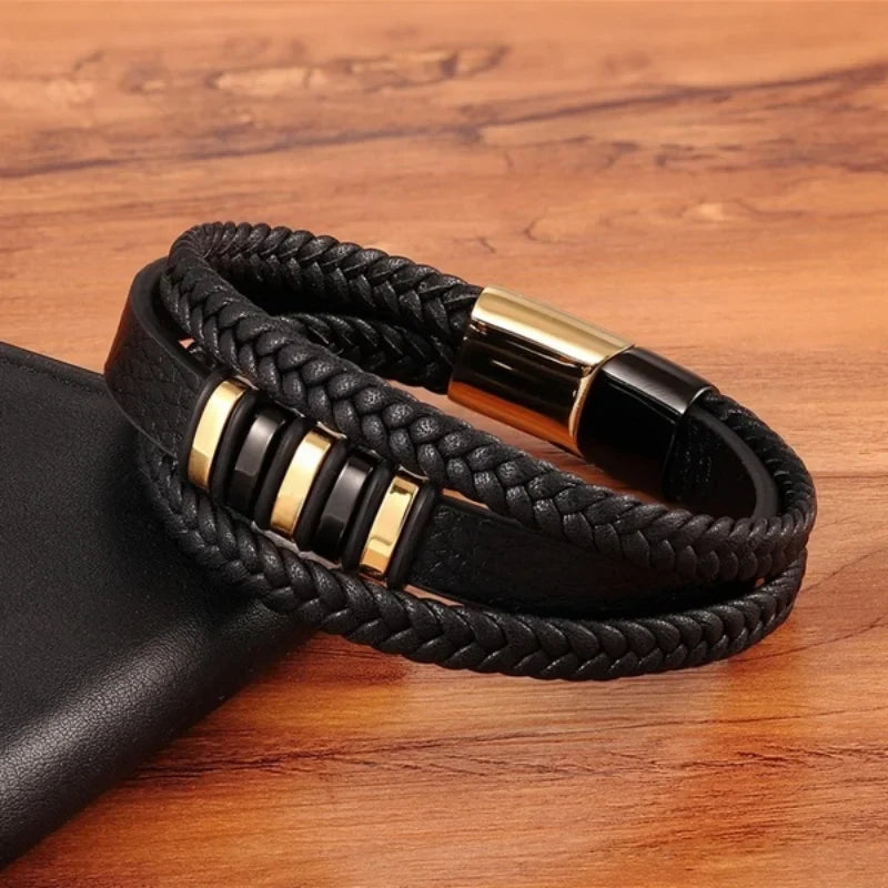 Pulsera de cuero trenzado con detalles dorados apoyada sobre una mesa de madera