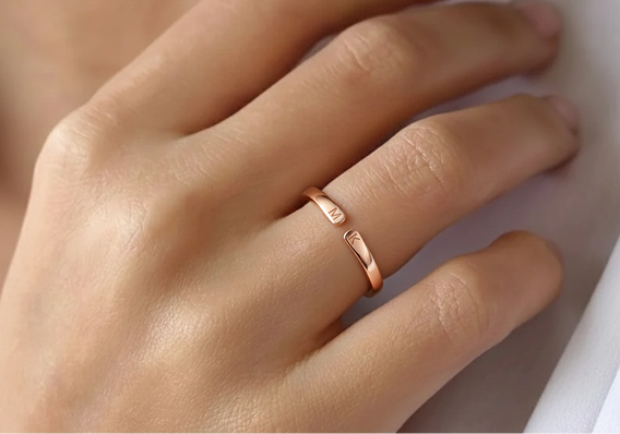 Anillo en oro rosa con dos iniciales, fino y discreto en la mano