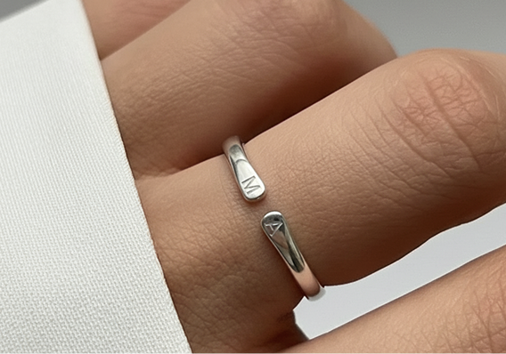 Anillo plateado con las iniciales M y A, una en cada extremo