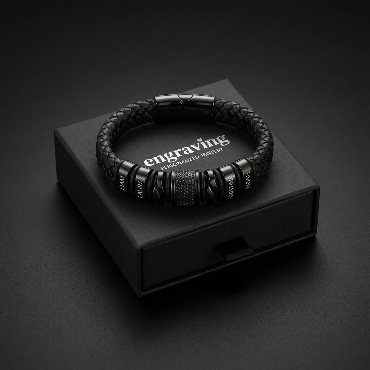 Pulsera negra con nombres grabados dentro de su caja de regalo