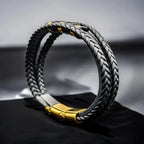 Pulsera de cuero trenzado negro con cierre magnético dorado, vista de perfil