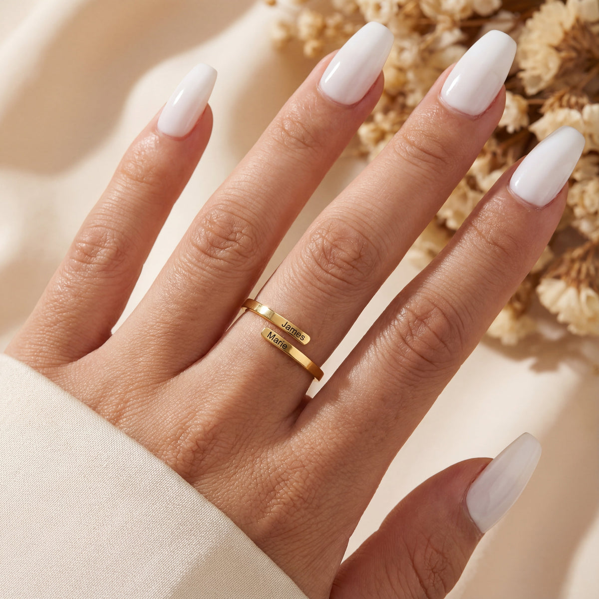 Anillo dorado con dos nombres puesto en la mano