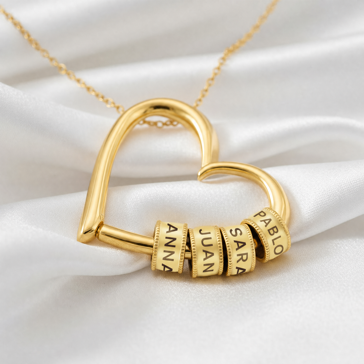 Colgante de corazón dorado con cuatro abalorios grabados con nombres