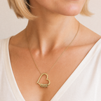 Mujer que lleva puesto el collar de corazón dorado con nombres