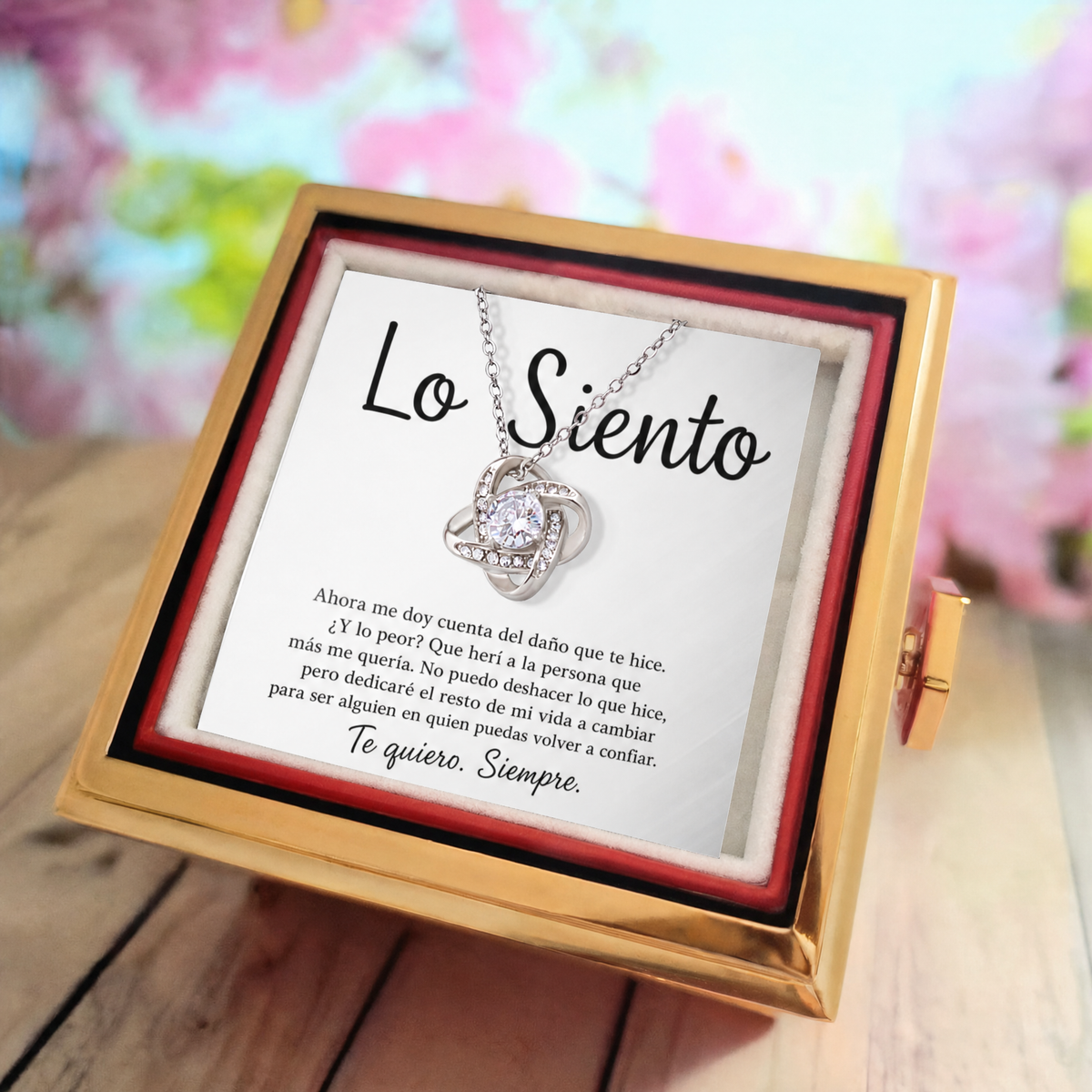 Collar Nudo de Amor en oro blanco sobre la tarjeta «Lo Siento», visto de cerca