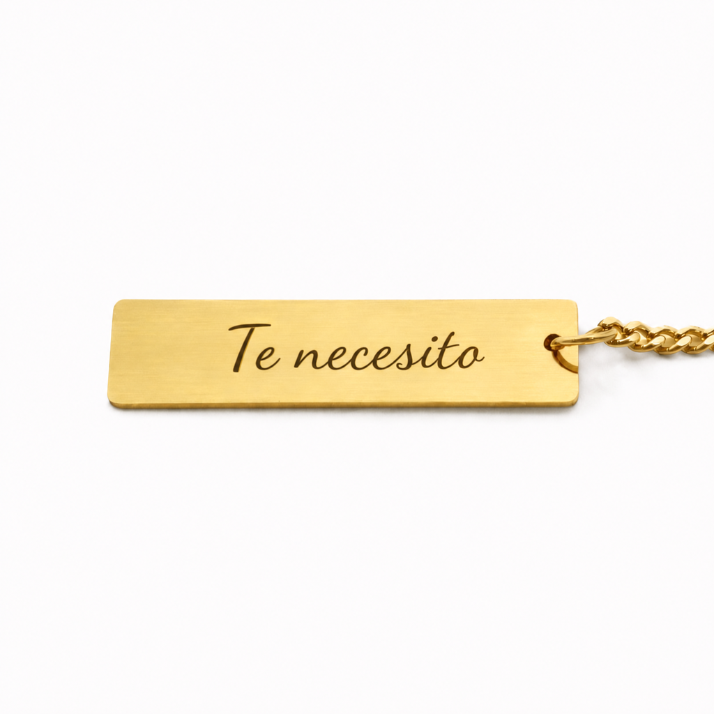 Llavero dorado con la dedicatoria «Te necesito» grabada detrás