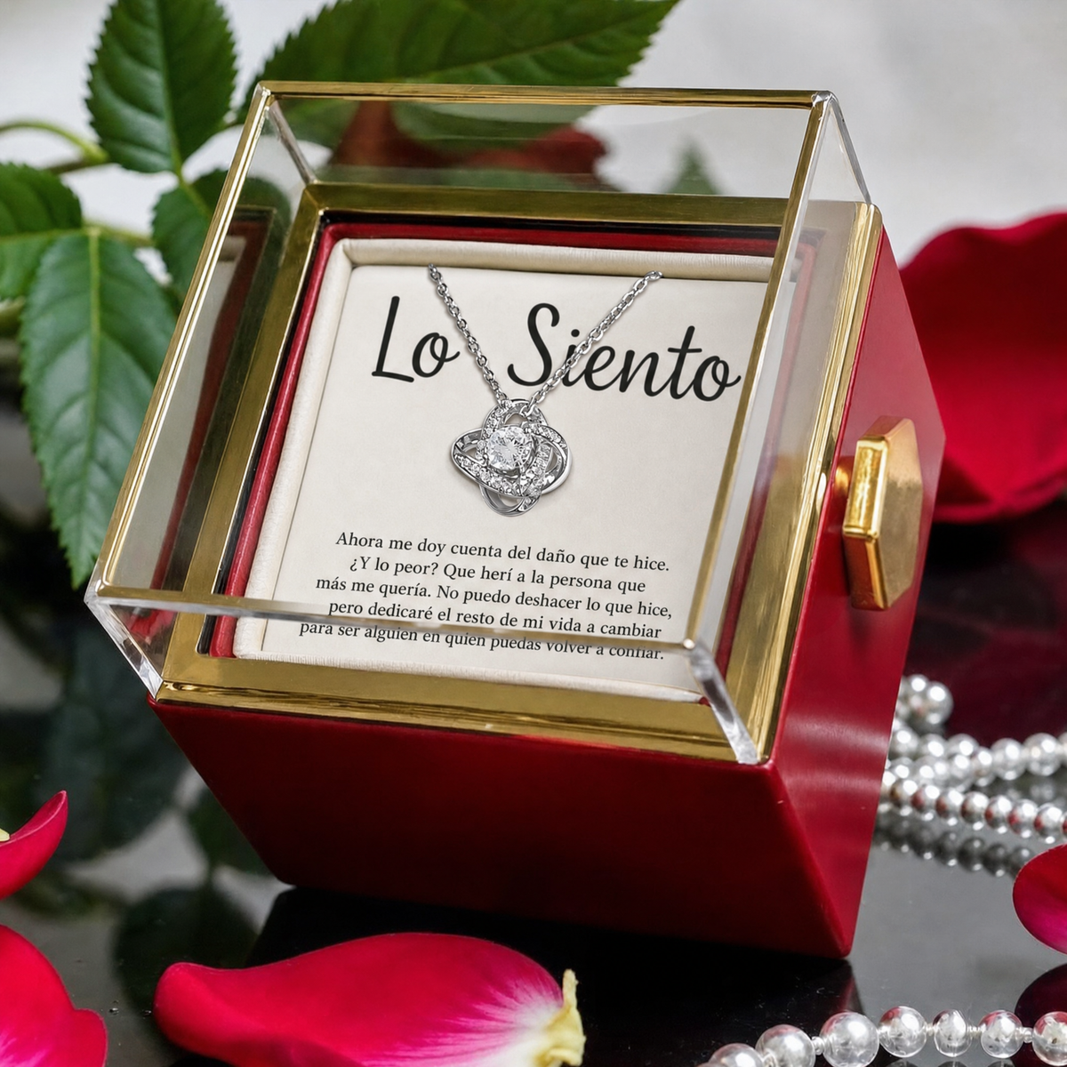 Caja abierta con el collar Nudo de Amor en oro blanco sobre la tarjeta «Lo Siento»