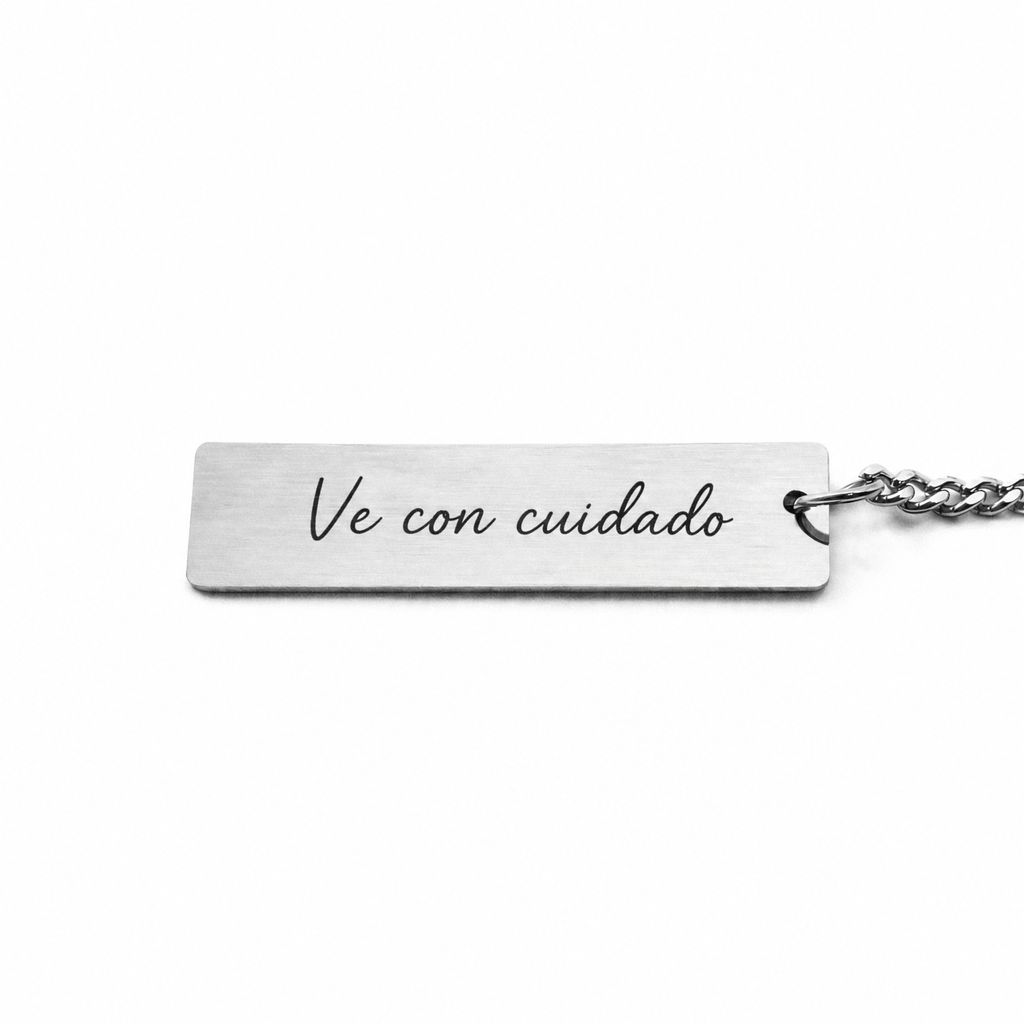Parte de detrás del llavero de acero con la dedicatoria «Ve con cuidado»