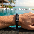 Pulsera negra con nombre grabado en la muñeca junto a una piscina, resistente al agua